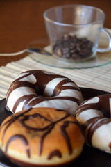 Donuts with chocolate on a brown plate on the table