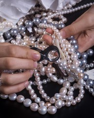 Choosing pearls necklaces and diamonds rings with the magnifying lens
