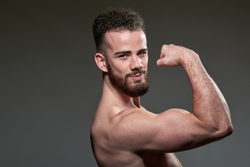 Obraz premium Handsome young body builder, on grey background