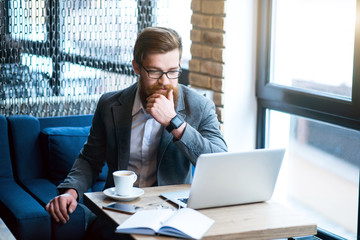 Pleasant bearded man drinking coffee      