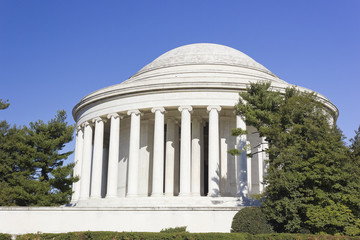 Ornamental plantings partially covering the circular colonnaded Ionic columns & shallow domed roof of the Jefferson Memorial, West Potomac Park, The Mall, Washington DC