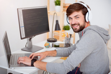 Man using laptop and looking at camera