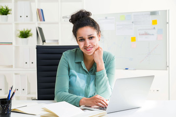 Smiling black woman using laptop