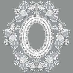 Lace empty flower frame in the shape of the medallion. White lacy cloth on a gray background.
