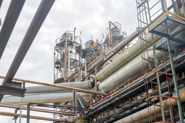 Industrial equipment and pipelines at the gas processing plant on a summer day