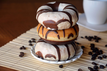 Traditional  donuts  with brown chocolate on the plate on the table