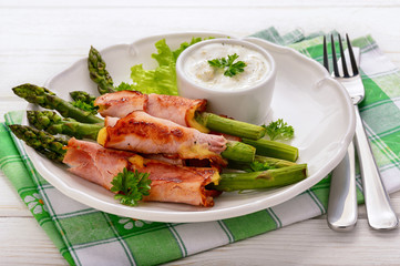Green asparagus grilled with ham and cheese, served with garlic sauce.