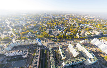 Fototapeta premium Aerial city view with crossroads, roads, houses, buildings, parks and parking lots, bridges. Copter shot. Panoramic image.