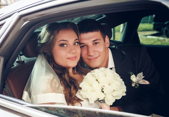 Portrait of happy newly wed couple in car