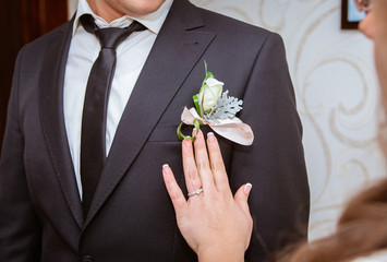 Bride adjusting beautiful groom's boutonniere