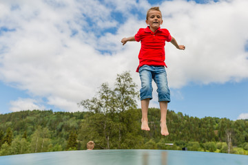 Young boy jumping on trampoline