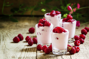 Homemade Pink Raspberry yogurt with fresh berries in glasses, vi