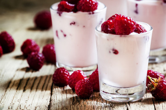 Homemade Pink Raspberry yogurt with fresh berries in glasses, vi