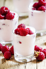 Homemade Pink Raspberry yogurt with fresh berries in glasses, vi