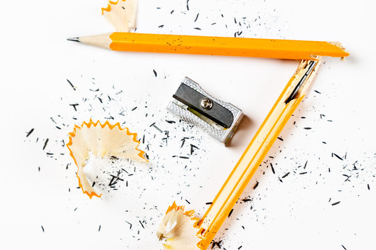 Broken pencil with metal sharpener and shavings.