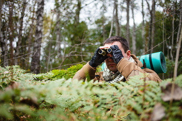Man with binoculars at a forest