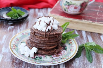 Chocolate pancakes with marshmallows at breakfast