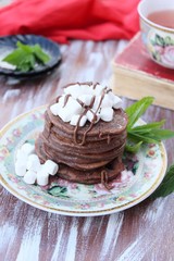 Chocolate pancakes with marshmallows at breakfast