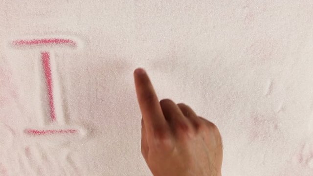 Men hand draws word I love yuo on the surface of sugar