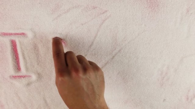 Men hand draws word I love yuo on the surface of sugar