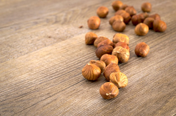 Primo piano di nocciole sgusciate su tavolo rustico. Alimentazione sana e naturale