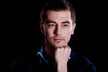 Portrait of handsome man in blue sweater on a dark background in the Studio