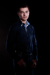 Portrait of handsome man in blue sweater on a dark background in the Studio