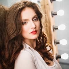 Naklejka premium Close-up portrait of beautiful sexy young woman with long brown hair in photostudio