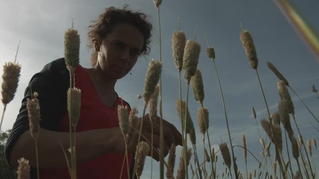 Donna con capelli ricci in un campo pensa e ricorda
