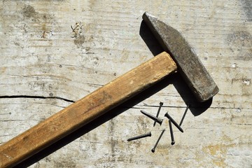 Hammer and nails on wood background