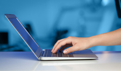 Businessman pressing modern laptop computer on colorful backgrou