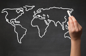Adult drawing world map on chalkboard