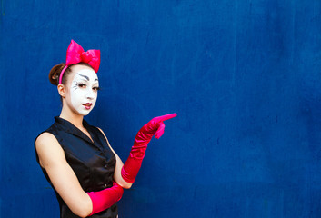 Mime points a finger at the center against a background of a blu