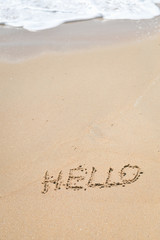 Top view of greeting sign drawing on the outside sand beach background