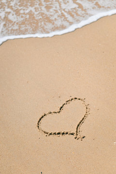 Top view of love heart drawn on sand. Background composition.