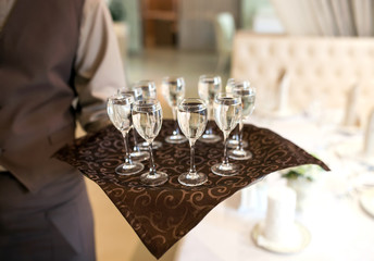 waiter with a tray welcomes visitors