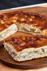 A piece of pie with chicken filling on a wooden plate