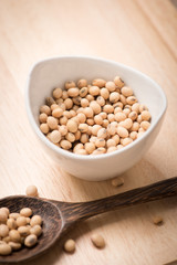 Soybeans in white ceramic bowl on wood block