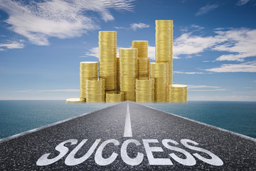 road to success concept with success text on asphalt road and stack of gold coins
