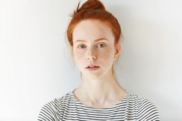 Close up of female teenager with healthy clean fresh skin with freckles wearing sailor shirt,...