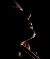 portrait of beautiful sensuality pensive girl profile with closed eyes in a dark, on a black background