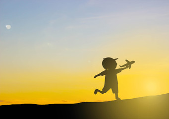 Fototapeta na wymiar silhouette Kids play Play plane with sunset