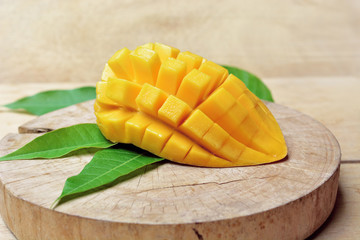 ripe mango with mango leaf in wooden background.