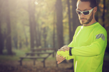 Jogger checking his running time in the park.