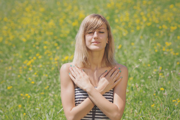 Naklejka na ściany i meble Girl meditating in a meadow.