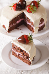 Cut a piece of cake with dark and white chocolate and strawberry. vertical
