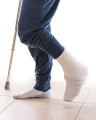 Young man with a broken ankle and a leg cast