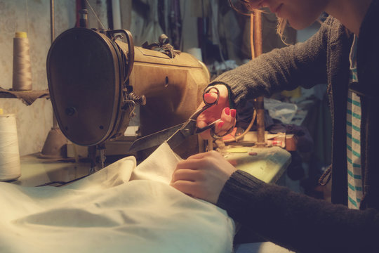 Tailor-girl working in her chaotic vintage shop.