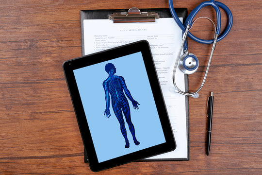 Medical picture on the tablet screen and stethoscope on wooden background