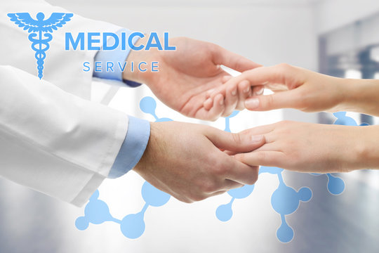 Male doctor holding patient's hands, on blurred background